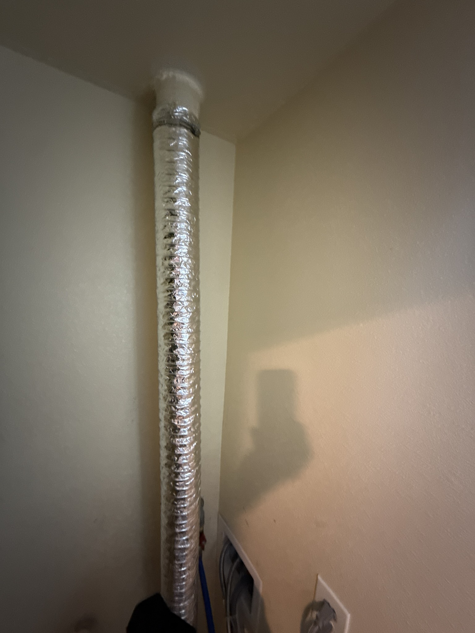 Technician inspecting a residential dryer exhaust duct connection at a South San Francisco home
