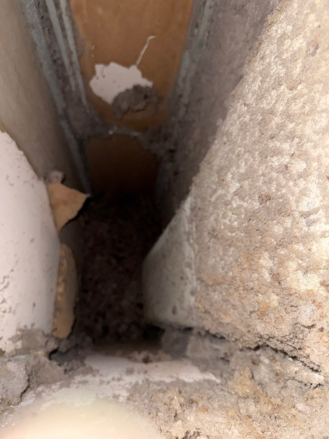 Inside a neglected dryer vent duct showing heavy lint accumulation on walls narrowing the airflow passage